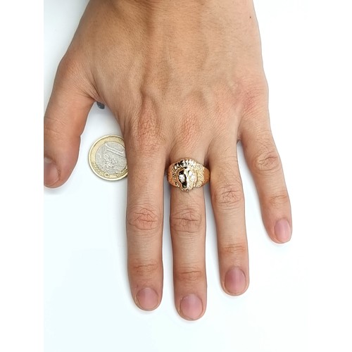 670 - An unusual 9 carat gold gentleman's lion head ring, set with White Sapphire stone eyes and mounted w... 