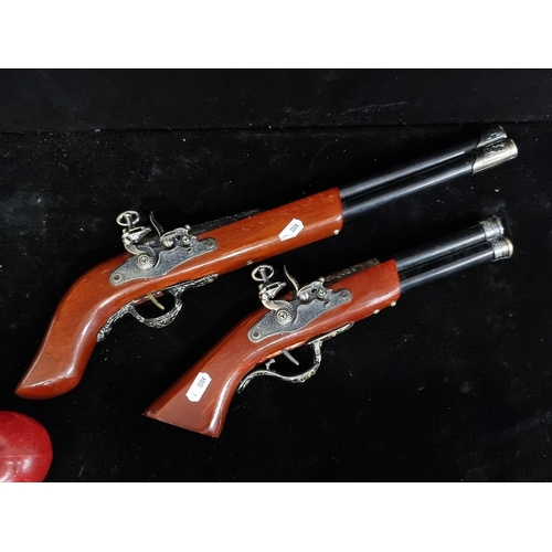 187 - Two toy double barrel musket replicas with ornate moulding on the shaft and featuring realistic trig... 