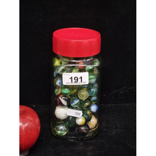 191 - A jar of vintage glass marbles featuring many examples including multi-coloured swirls to centre and... 