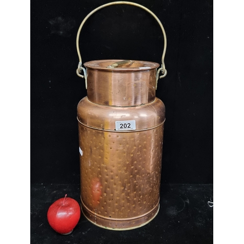 202 - An eye-catching vintage, large copper and brass milk churn. The surface features embossed detail and... 