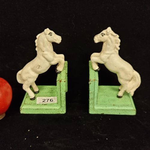 276 - Two heavy cast iron bookends in the form of rearing horses.