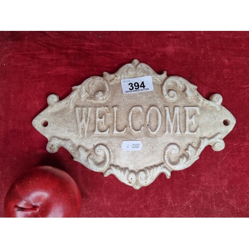 394 - A charming cast metal welcome sign with an acanthus leaf detail. H16cm X 26cm