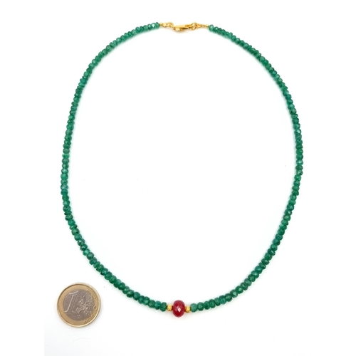 656 - A single strand Emerald necklace of 70 carats, with a beautiful large Ruby centre gemstone  and set ... 