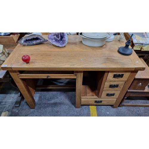 695 - A very heavy solid oak desk with four drawers and a keyboard shelf, all with cast metal drop ring ha... 