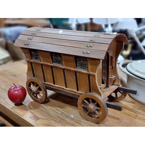 697 - A charming, handmade wooden model of a traditional caravan with fully functioning wheels and curtain... 