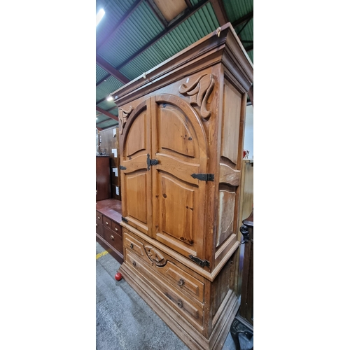 711 - An impressive solid wood antique pine wardrobe with high relief carvings throughout, three drawers t... 