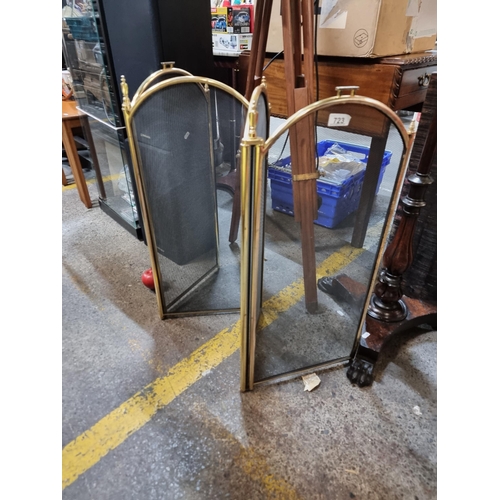 723 - A four-part, folding fire guard. With a brass frame and a black metal mesh.