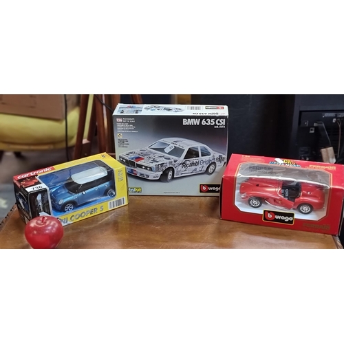 736 - Three model cars including a Burago die cast Ferrari Testa Rossa (1957) (scale: 1/24), a Mini Cooper... 