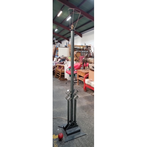 741 - A very tall irish floor standing lamp with a geometric cast metal stand and base.