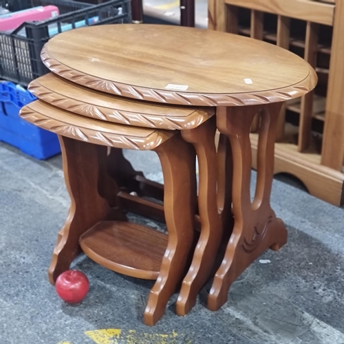 749 - A nice set of three wooden nesting tables, the smallest of which has a second tier below for storage... 