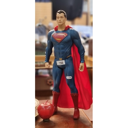 750 - A large figurine of Superman with articulated arms and legs and red fabric cape.