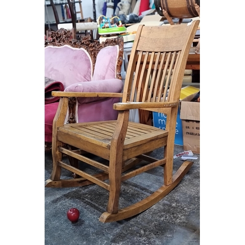 799 - A handsome, well made solid wood rocking chair with high arms, slatted seat and back.