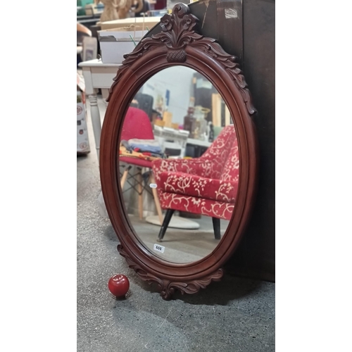 809 - A very elegant oval wall mirror. Housed in a Victorian style wooden frame. Featuring bevelled edges ... 