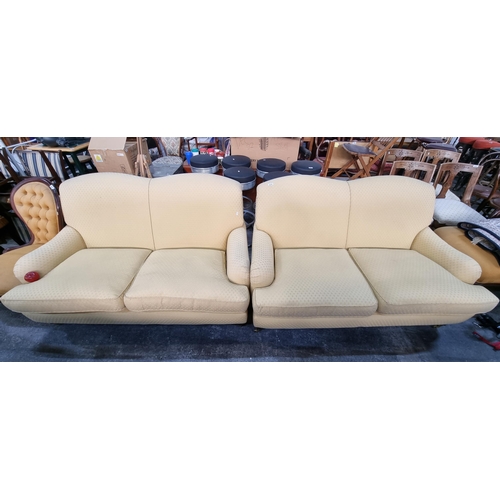 819 - A pair of vintage, two-seater sofas. Upholstered in a pretty, butter yellow with subtle diamond patt... 