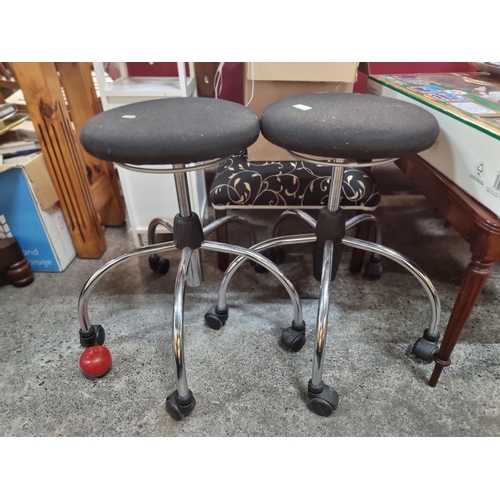 820 - A pair of terrestrial style swivel stools. With padded seats and oversized spider bases on castors. ... 