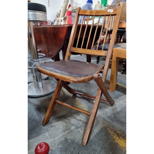 829 - A charming, folding antique chair. Featuring turned rails and a burgundy leather seat.