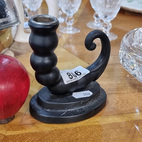 866 - A unique antique chamber candle holder in an abstract curved form, atop of a plinth. H12cm