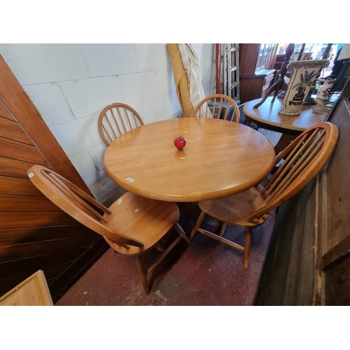 879 - A neatly proportioned circular kitchen table with four matching spindle back chairs. In good clean c... 