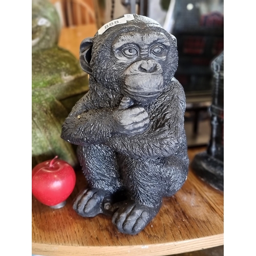 888 - A charming heavy reconstituted stone sculpture of a baby chimpanzee with hand painted finish.