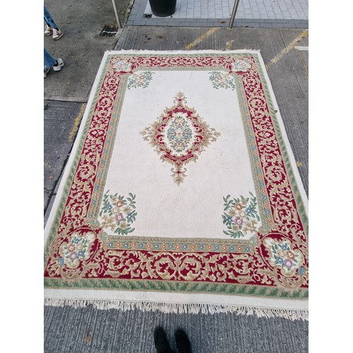 783 - Star lot : A beautiful large floor rug in shades of cream, red and blue with traditional centre meda... 