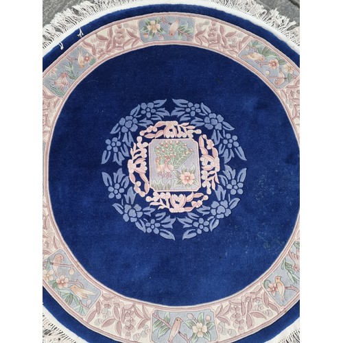 784 - Star lot : A charming, round Chinese floor rug in a deep blue shade and with a floral design. With f... 