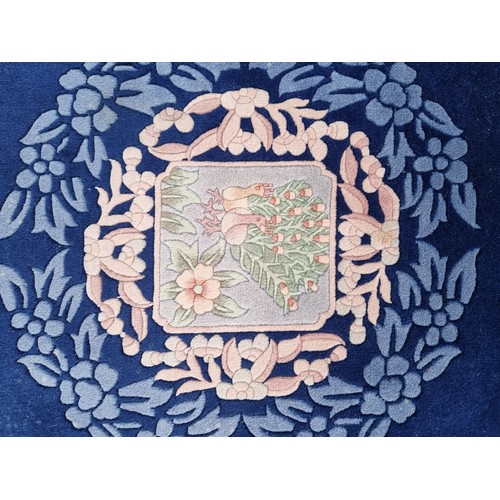 784 - Star lot : A charming, round Chinese floor rug in a deep blue shade and with a floral design. With f... 