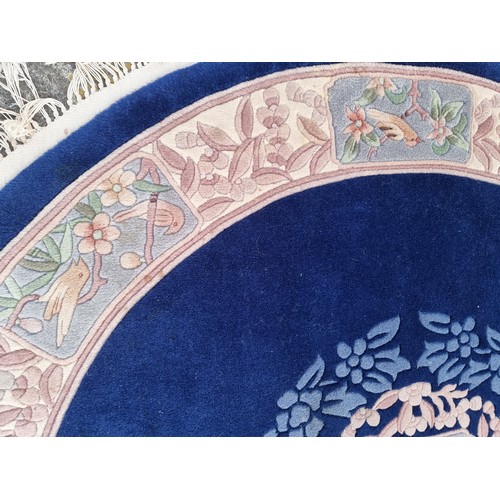 784 - Star lot : A charming, round Chinese floor rug in a deep blue shade and with a floral design. With f... 