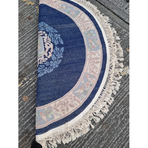 784 - Star lot : A charming, round Chinese floor rug in a deep blue shade and with a floral design. With f... 