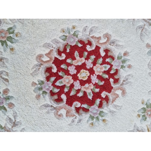 785 - A charming Chinese round rug in shades of cream and red. With fringe trim. D135cm round rugs are to ... 