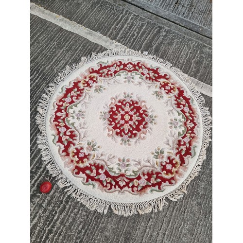 785 - A charming Chinese round rug in shades of cream and red. With fringe trim. D135cm round rugs are to ... 