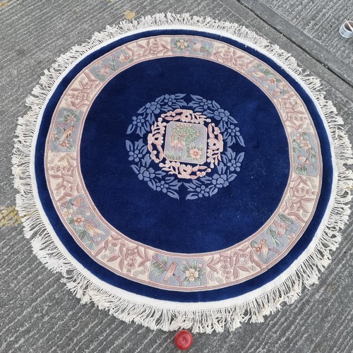 784 - Star lot : A charming, round Chinese floor rug in a deep blue shade and with a floral design. With f... 