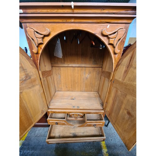 711 - An impressive solid wood antique pine wardrobe with high relief carvings throughout, three drawers t... 