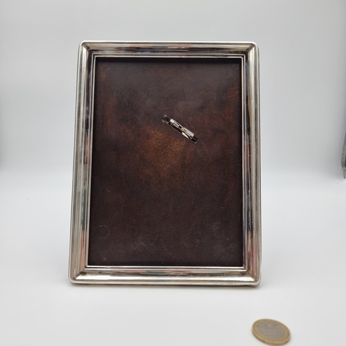 613 - A contemporary, sterling silver photo frame with wooden backing. Hallmarked ''925. BJF''. H20cm x W1... 