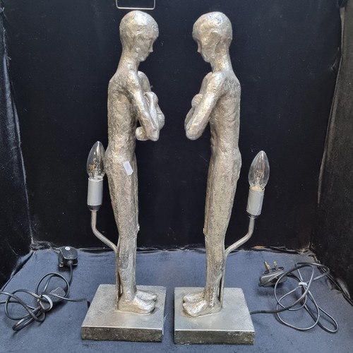 708 - A pair of silver toned figurative lamps with single bulb to back.