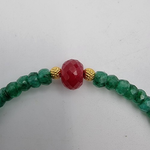 656 - A single strand Emerald necklace of 70 carats, with a beautiful large Ruby centre gemstone  and set ... 