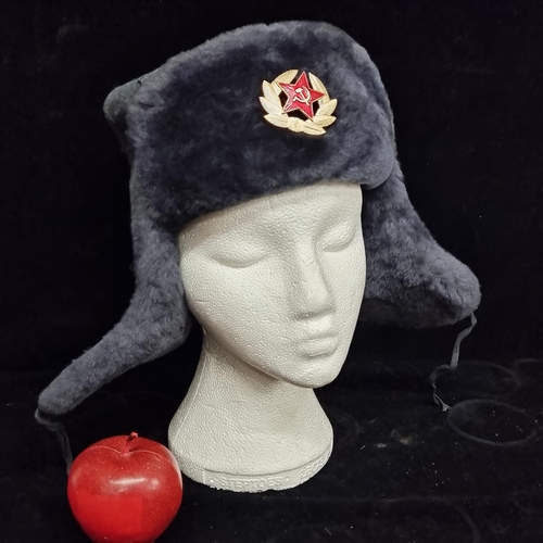 129 - A genuine wool Ushanka hat. A Russian military example with gold toned pin badge. Size 56. Featuring... 