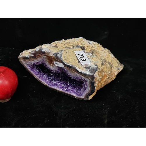 229 - A beautiful geode rock with amethyst crystal interior. L20cm x H13cm Very heavy piece and beautiful ... 