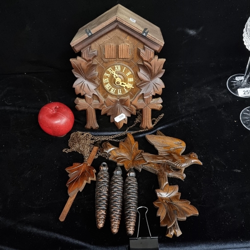 257 - A gorgeous traditional German wooden cuckoo clock, with the characteristic carved leaf boarder, perc... 