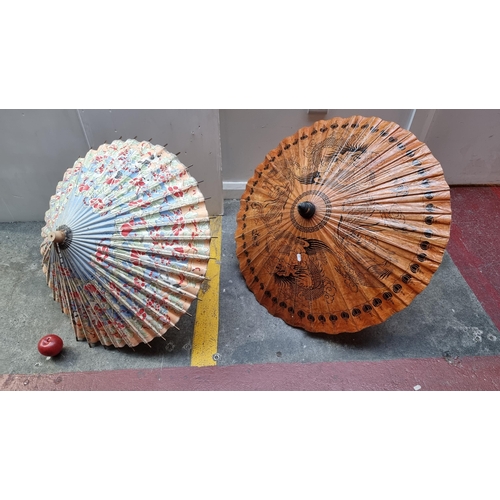 299 - Two stunning vintage hand painted parchment parasols one featuring a figurative design and the other... 