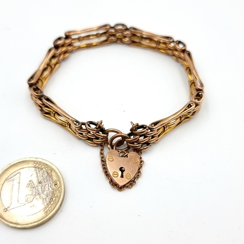 30 - Star Lot: A fine example of a 9 carat Gold gate link bracelet, with a padlock clasp and safety chain... 