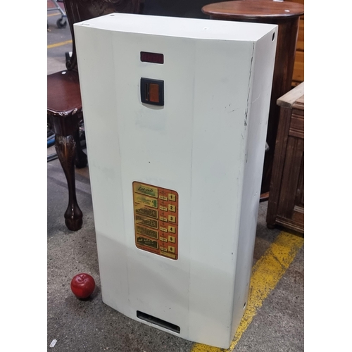 A washroom vending machine in a matte white finish, with wall-mounting ...