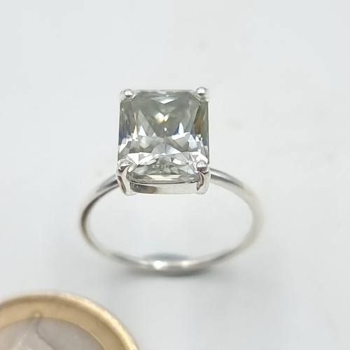 863 - A sparkling emerald cut white 4 carat moissanite solitaire ring set in a sterling silver band. ring ... 