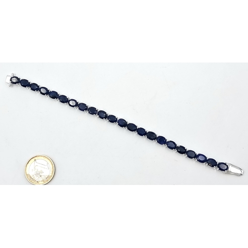 866 - Star lot : A striking dark sapphire tennis bracelet set in Sterling Silver , 19 grams. 18cm long. Al... 