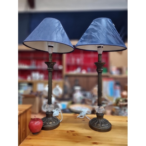 878 - A pair of elegant table lamps with night blue, textured shades and fluted brass stems adorned by a c... 