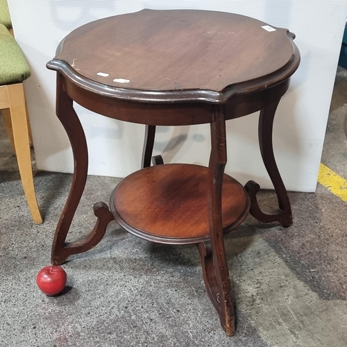 881 - An elegant occasional table with a round top featuring a graduated edge and a shelf to base. With un... 