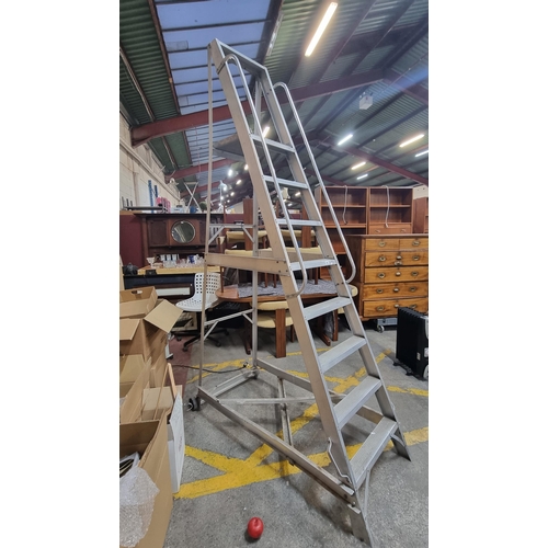 907 - A very useful, A frame mobile step ladder. Designed with 8 steps and a large podium step to stop for... 