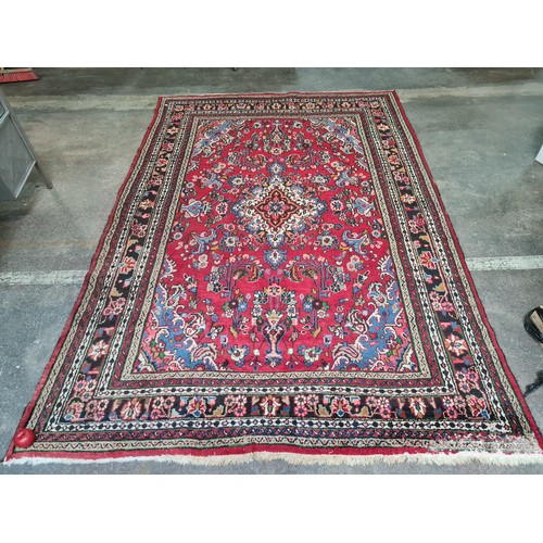 754 - Star lot : A beautiful hand knotted wool rug, in deep shades of red, green and blue. L307cm x W208cm...