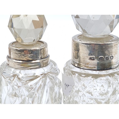55 - Two hob nail cut glass perfume bottles, set with silver collars. The first is hallmarked Birmingham,... 