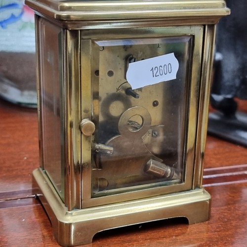 204 - An elegant antique Mechanical mantle clock housed in a brass frame with beveled glass panels showing... 