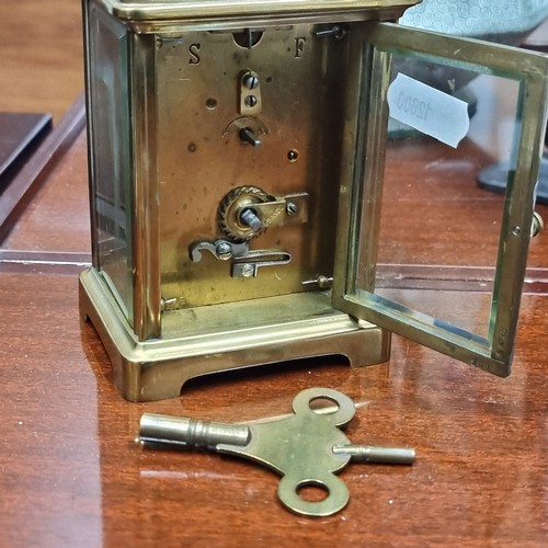 204 - An elegant antique Mechanical mantle clock housed in a brass frame with beveled glass panels showing... 